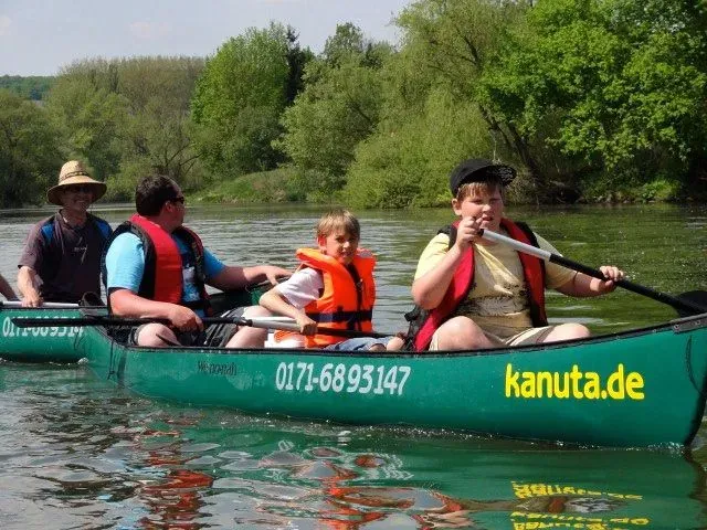 kanuverleih-kanutouren-kanuvermietung-kanuta-16 Eine Gruppe von Menschen paddelt in einem Kanu auf einem Fluss.