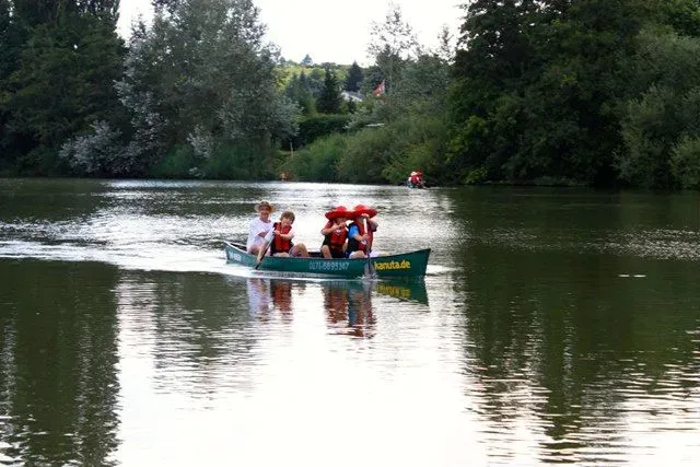 kanuverleih-kanutouren-kanuvermietung-kanuta-24 Eine Gruppe von Menschen paddelt in einem Kanu auf einem See.