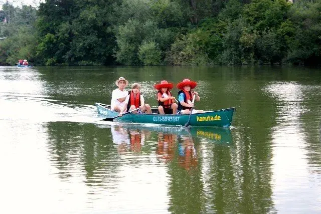 kanuverleih-kanutouren-kanuvermietung-kanuta-25 Eine Gruppe von Menschen paddelt in einem Kanu auf einem Fluss.