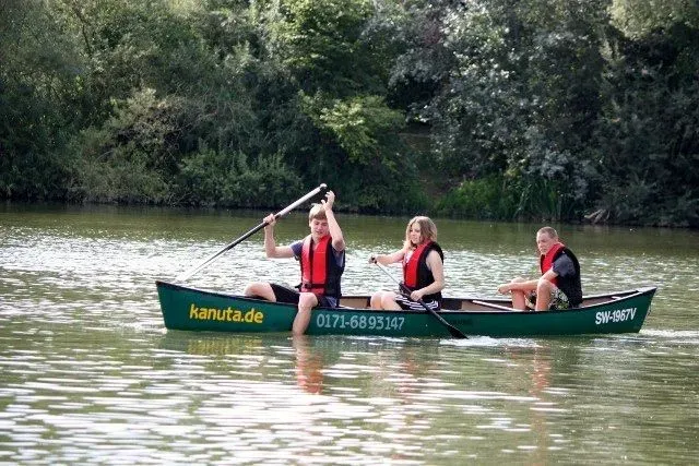 kanuverleih-kanutouren-kanuvermietung-kanuta-29 Drei Personen in einem Kanu auf einem See.