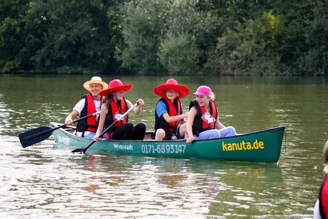 kanuverleih-kanutouren-kanuvermietung-kanuta-30 Eine Gruppe von Menschen paddelt in einem Kanu auf einem Fluss.