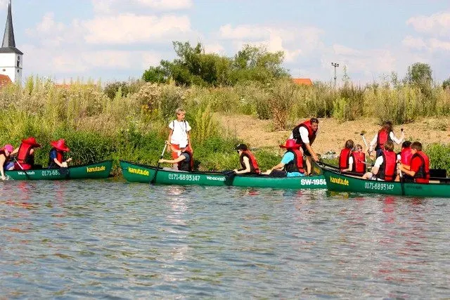kanuverleih-kanutouren-kanuvermietung-kanuta-38 Eine Gruppe von Menschen paddelt in einem Kanu auf einem Fluss.