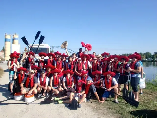 kanuverleih-kanutouren-kanuvermietung-kanuta-46 Eine Gruppe von Menschen mit roten Hüten posiert für ein Foto.