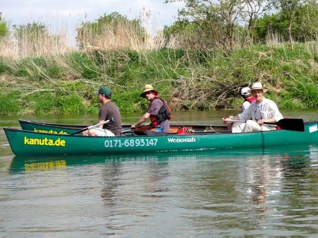Eine Gruppe von Menschen in einem Kanu auf einem Fluss.