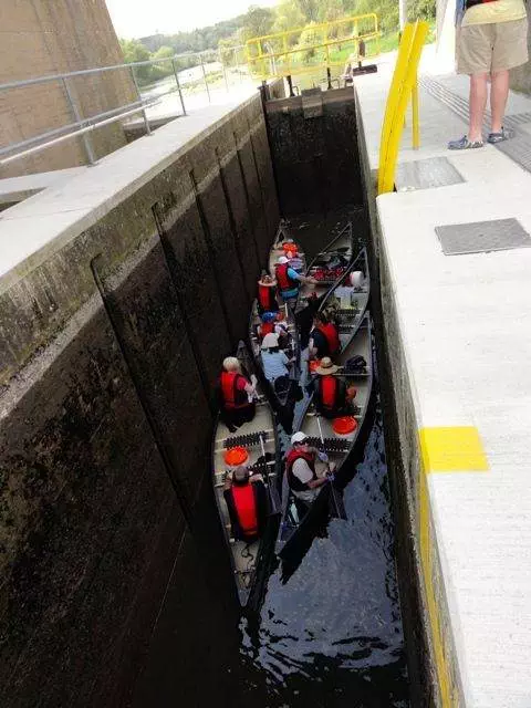 Eine Gruppe von Menschen in Kanus in einer Schleuse.