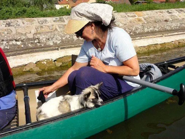 Eine Frau in einem Kanu mit einem Hund.