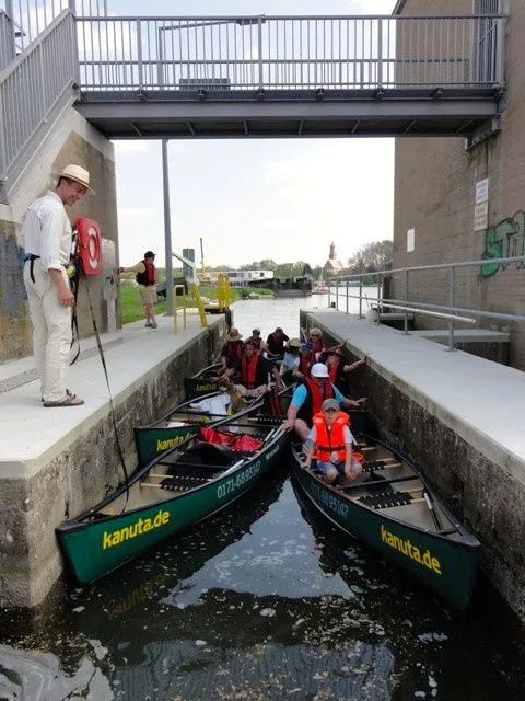Eine Gruppe von Menschen in Kanus auf einem Kanal.