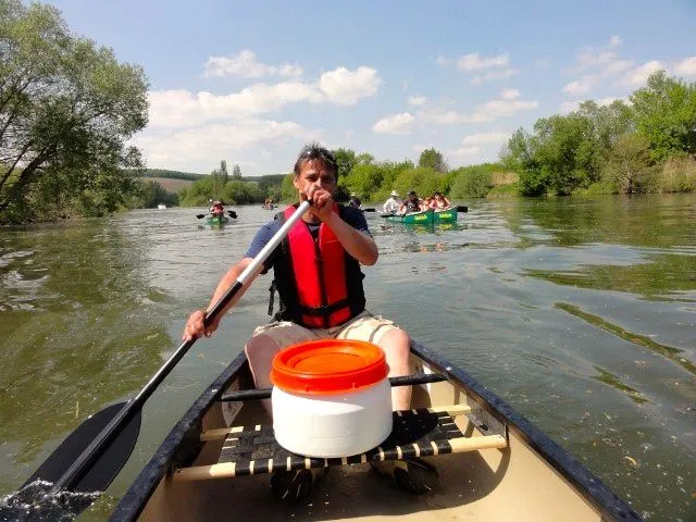 Ein Mann paddelt mit einem Kanu auf einem Fluss.