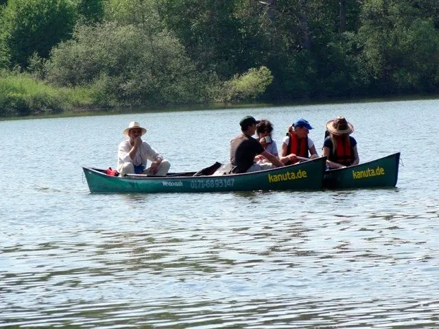 Eine Gruppe von Menschen in einem Kanu auf einem See.