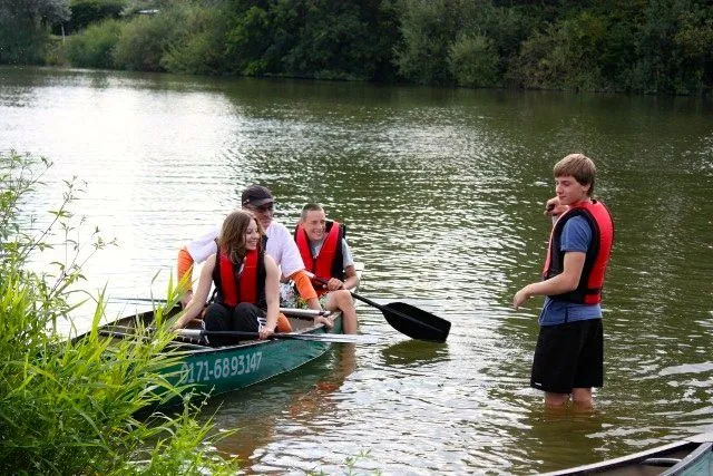 Eine Gruppe von Menschen in einem Kanu auf einem Fluss.