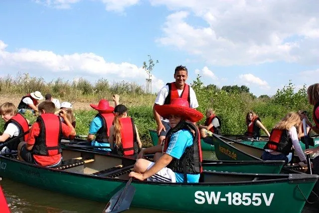Eine Gruppe von Menschen in Kanus auf einem Fluss.